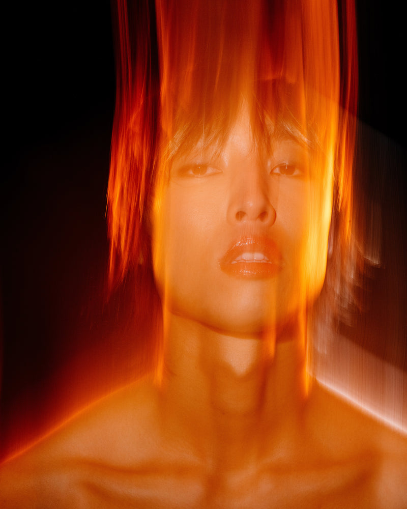 A man wearing lip oil and eyeliner.